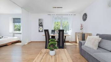 Ein modernes Wohnzimmer mit einem Holztisch, einem grauen Sofa und einem Essbereich mit Tisch und Stühlen.