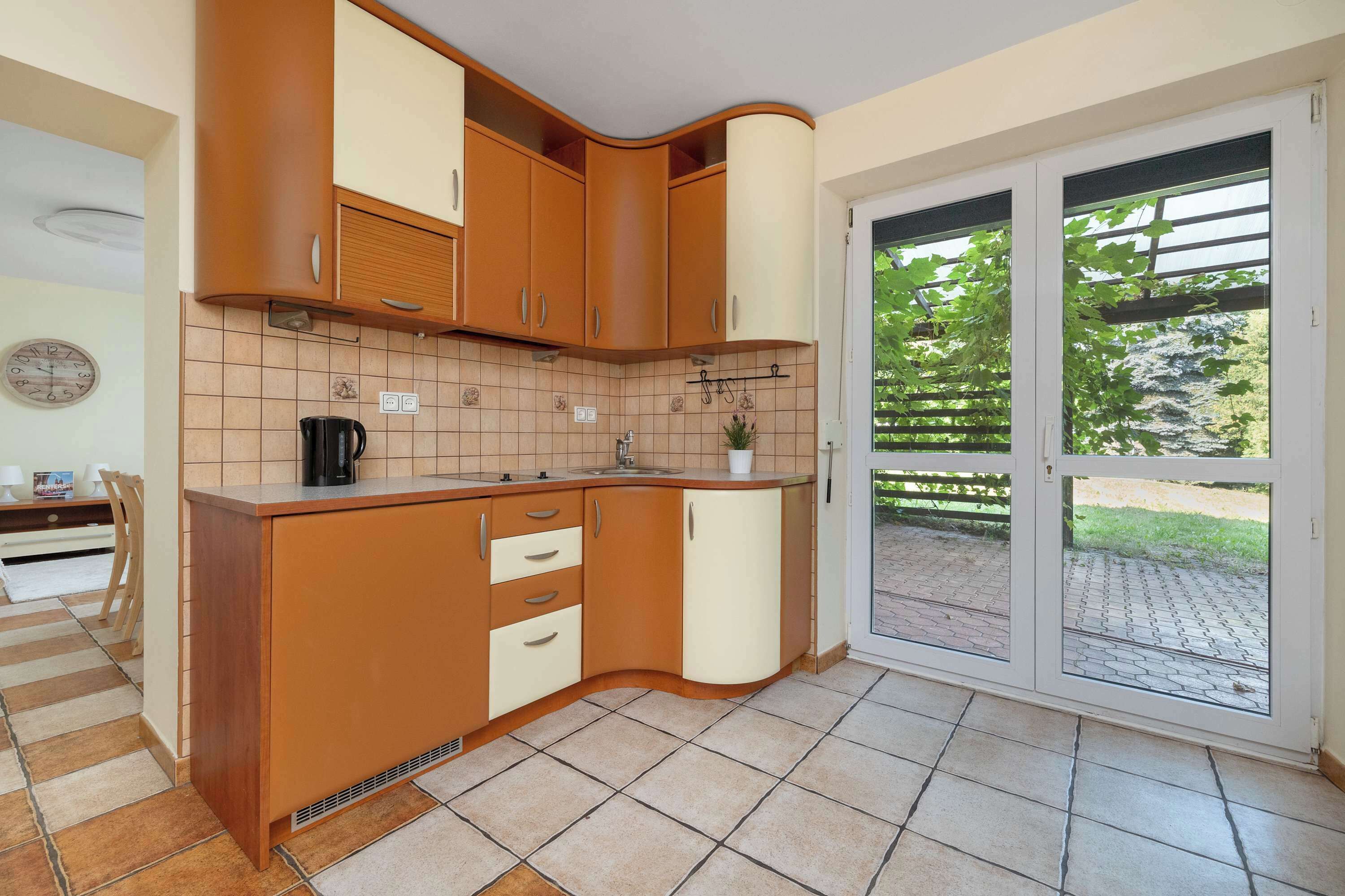 Une cuisine avec des meubles de rangement en bois, un évier et une fenêtre sur le côté droit.