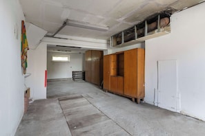 Ein schmaler Flur mit einem Holzschrank, einer weißen Tür und einem Fenster am Ende.