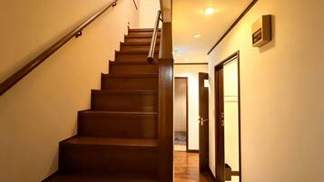 A wooden staircase with a handrail leading to a door at the top.