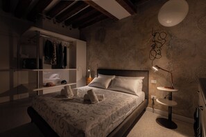 A bedroom with a bed, bedside lamps, a wardrobe, and a wall with a decorative pattern. - Ea casa de mì2 – The Enchantment of Living Venice (Venezia)