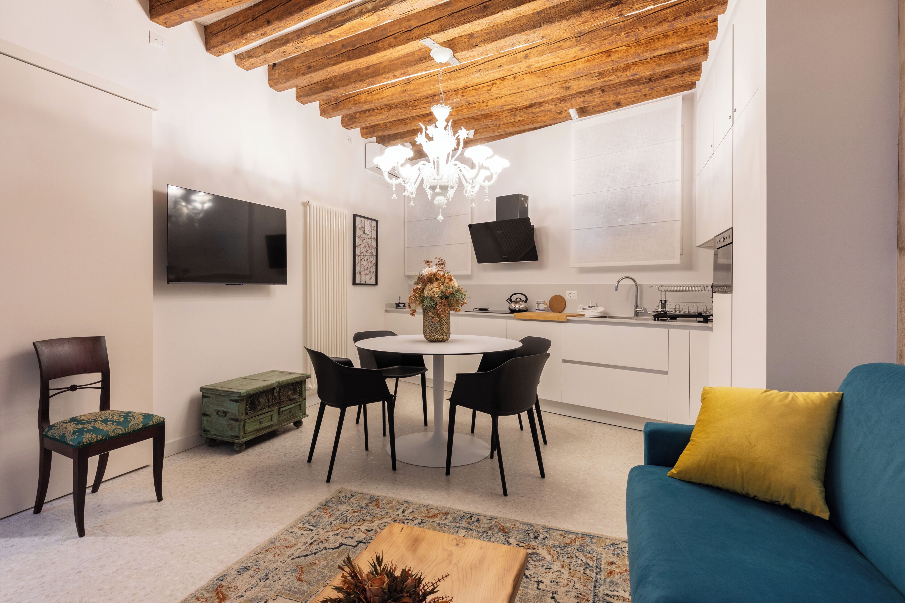A modern living space with a dining area, kitchen, and seating area.