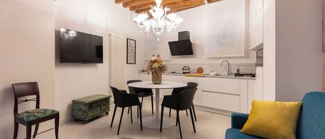 A modern living space with a dining area, kitchen, and seating area.