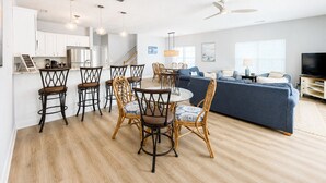 Um espaço moderno com área de jantar, cozinha e sala de estar.