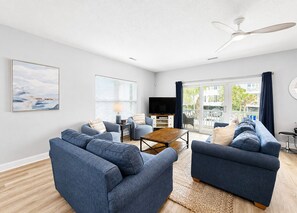 A modern living room with a sofa set, a coffee table, a flat-screen TV, and a ceiling fan. - Lady Luck - Second Row in Surfside Beach (Surfside Beach)