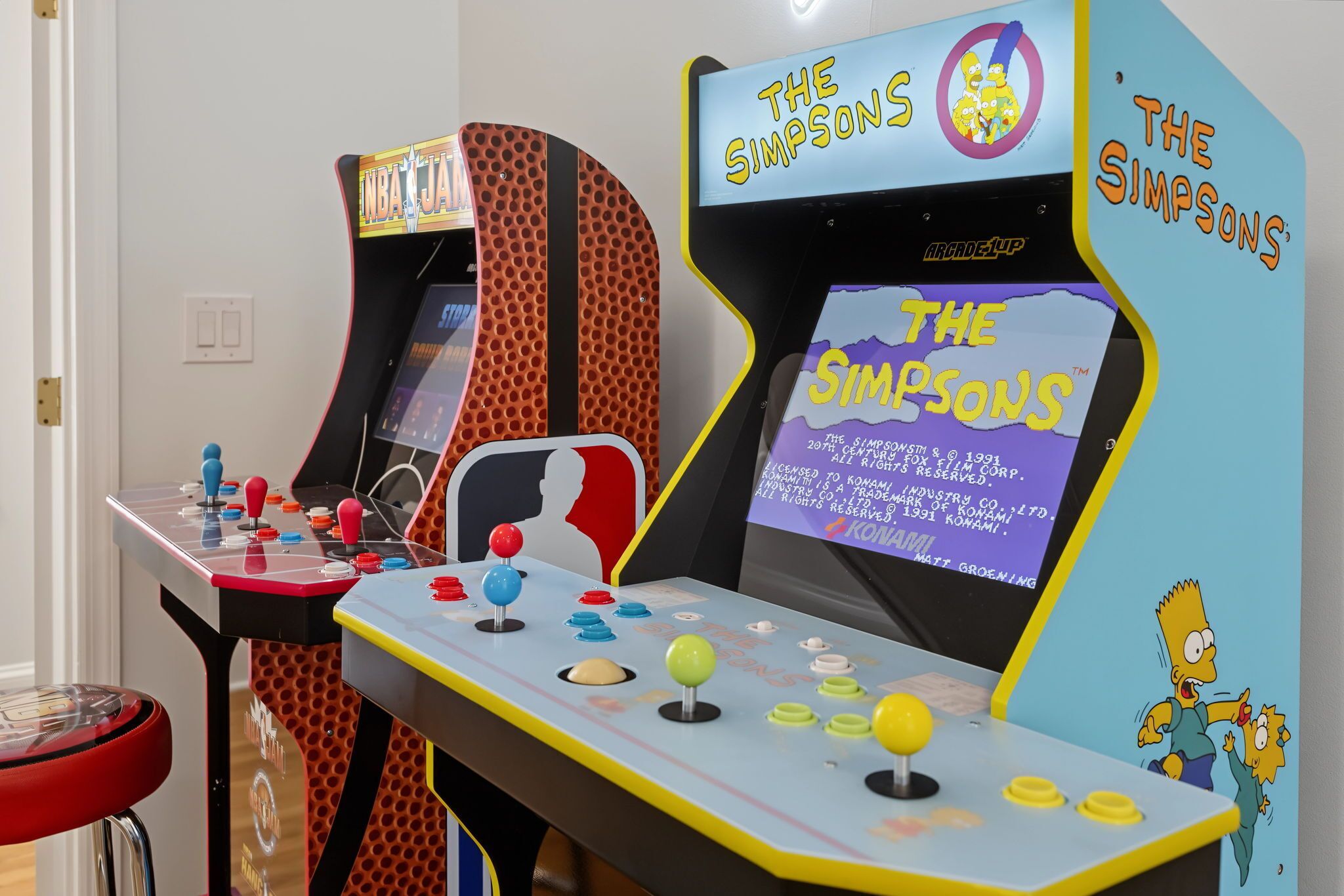 Dos máquinas de arcade con la marca 'The Simpsons', que incluyen controles de joystick y botones.