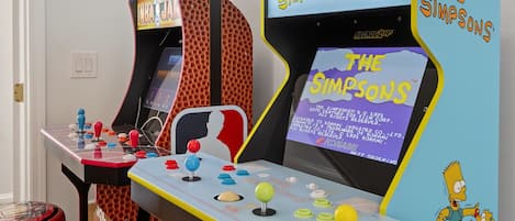 Dos máquinas de arcade con la marca 'The Simpsons', que incluyen controles de joystick y botones.