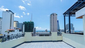 Una terraza en la azotea con vistas al horizonte de la ciudad y al océano.