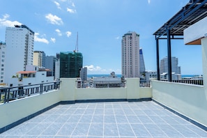 Terraço no telhado com vista para o horizonte da cidade e para o oceano.