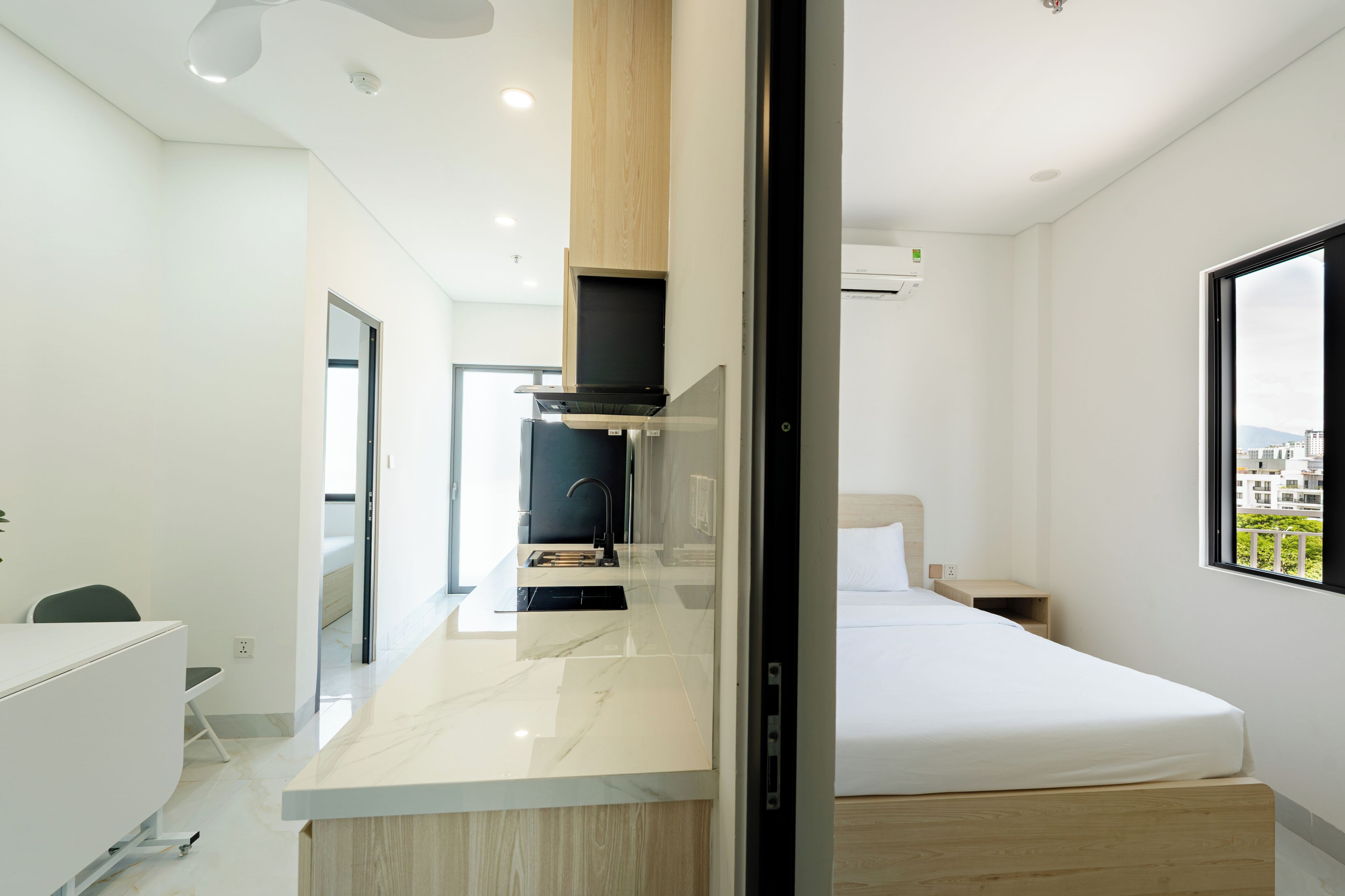 Una habitación de hotel moderna con cama, escritorio y kitchenette.