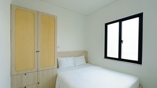 Un dormitorio con una cama, un armario y una ventana.