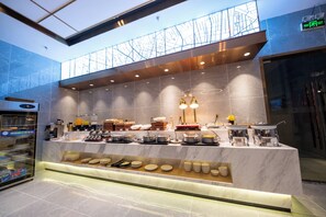 A modern buffet setup with a variety of dishes and a clear exit sign.