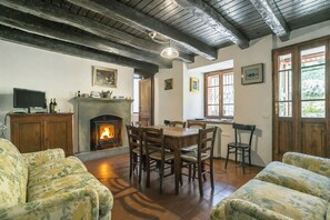 A cozy living room with a fireplace, wooden furniture, and a television.