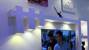 Una sala de estar moderna con un televisor de pantalla plana montado en una pared blanca, rodeada de estanterías empotradas e iluminación empotrada.