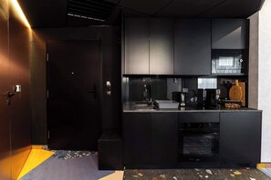 A modern kitchen with black cabinetry, a built-in oven, a microwave, and a coffee machine. - Sienna 8D | Comfortable Apartment | Parking (Stronie Śląskie)