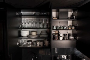 A kitchen with shelves containing glassware, plates, bowls, and jars of spices. - Sienna 8D | Comfortable Apartment | Parking (Stronie Śląskie)