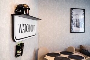 A wall-mounted sign with the text 'WATCH OUT' and a helmet above it. - Sienna 8D | Comfortable Apartment | Parking (Stronie Śląskie)