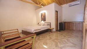 Un dormitorio con cama, un banco de madera, un cuadro en la pared y un armario de madera.