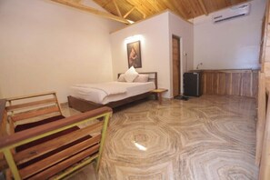 Un dormitorio con cama, un banco de madera, un cuadro en la pared y un armario de madera.