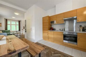 Une cuisine moderne avec des meubles en bois, une cuisinière en acier inoxydable et un four à micro-ondes.