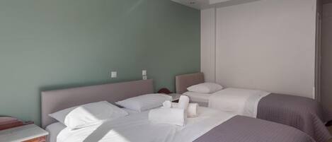 A hotel room with two beds, a nightstand, and a window.