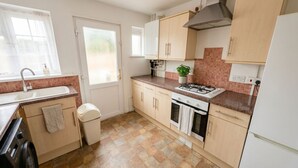 A kitchen with a sink, stove, oven, and cabinets. - Peaceful 4BDR Home with Garden in Slough (Berkshire)