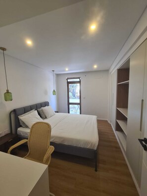 Une chambre à coucher avec un lit, une chaise, une armoire et une fenêtre.