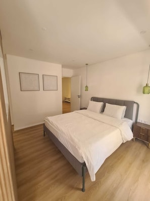 Ein Schlafzimmer mit einem Bett, Nachttischen und zwei Wandleuchten.