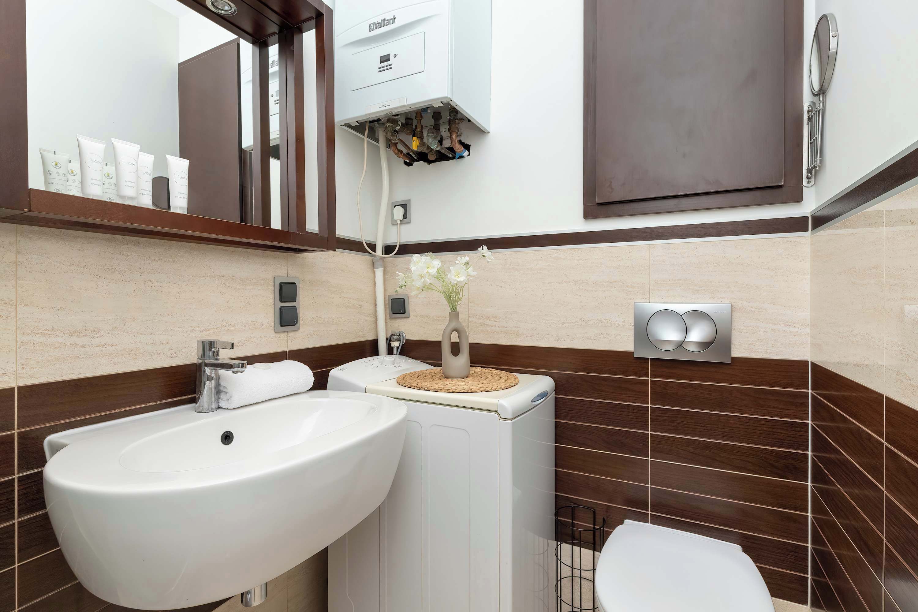 Un baño moderno con un lavamanos grande, un inodoro y una ducha.