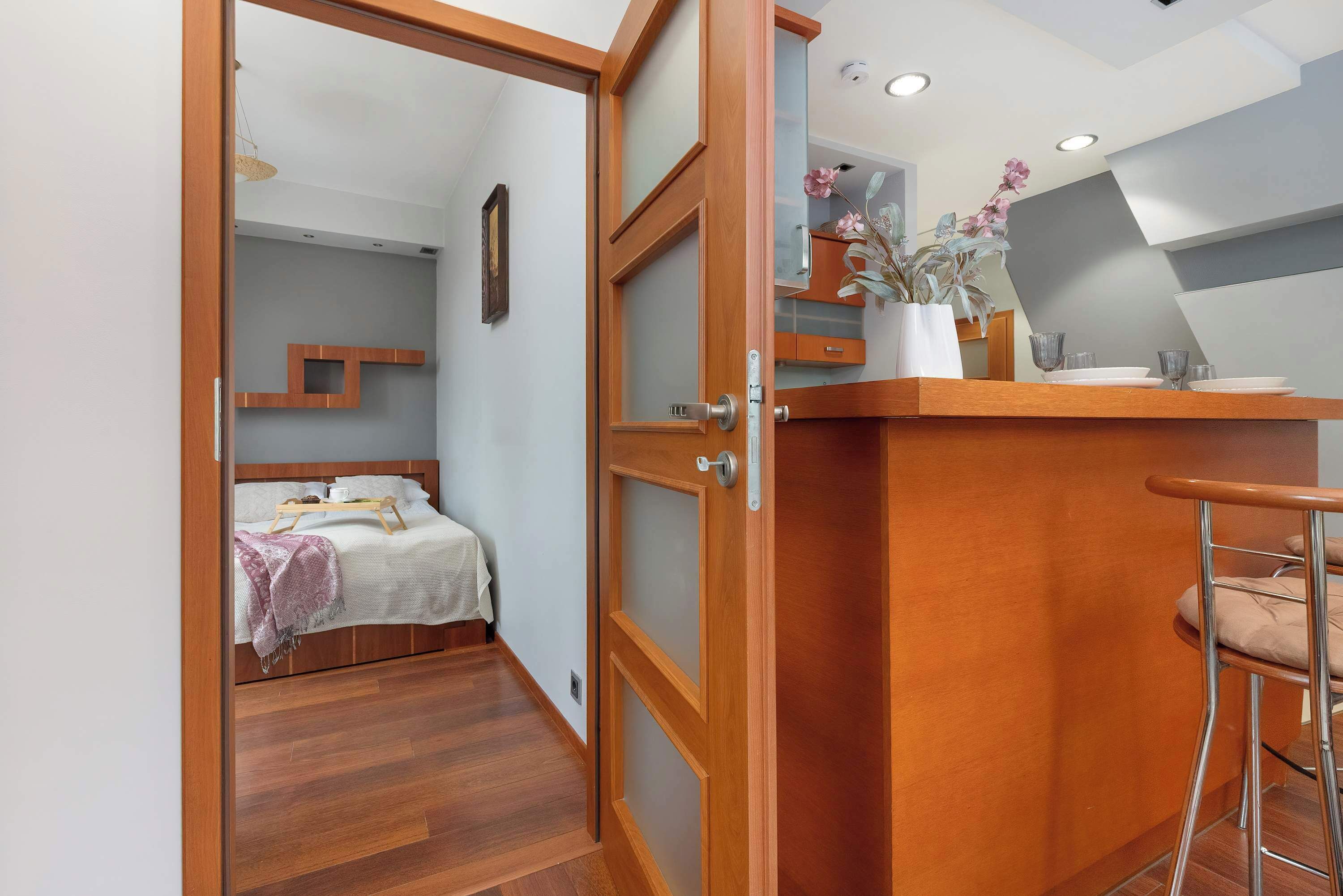 Una habitación con una cama, un escritorio de madera y una silla.