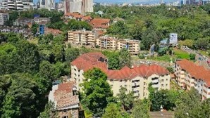 Un área residencial con edificios de varios pisos, rodeada de vegetación.