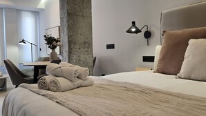 Moderni hotellihuone, jossa on suuri sänky, työpöytä ja tuoli.
