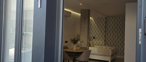A modern interior with a dining area, a sofa, and a patterned wall.