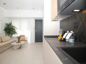 A modern kitchen with a black countertop, a built-in stove, and a dark backsplash. - Cozy studio near beach - 4 guests (Málaga)
