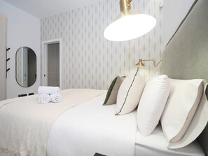 A hotel room with a bed, a bedside lamp, a mirror, and a towel on the bed. - Cozy studio near beach - 4 guests (Málaga)