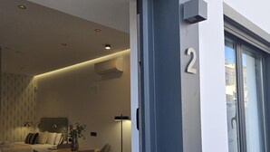 Ein modernes Wohnzimmer mit einer Couch, Esstisch, Stühlen und einer kleinen Pflanze.
