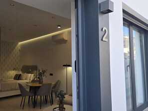 Ein modernes Wohnzimmer mit einer Couch, Esstisch, Stühlen und einer kleinen Pflanze.
