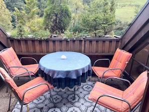 A round table with a white tablecloth and four orange-striped chairs.