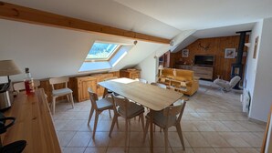 Ein Loft-Zimmer mit Essbereich, Holzmöbeln, einem Fernseher und einem Kamin.