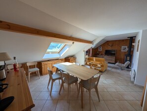 Ein Loft-Zimmer mit Essbereich, Holzmöbeln, einem Fernseher und einem Kamin.