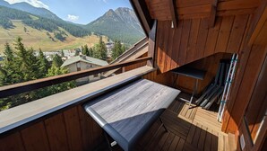 Ein hölzerner Balkon mit Blick auf eine Berglandschaft.