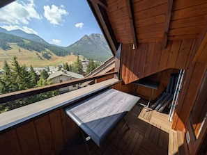 Ein hölzerner Balkon mit Blick auf eine Berglandschaft.