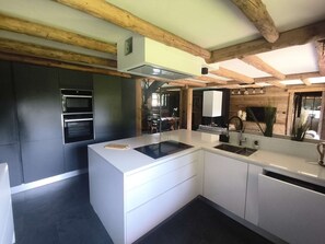 A modern kitchen with white cabinetry, a built-in oven, and a large island with a sink. - Spacious apartment near center - 8 guests (Arâches-la-Frasse)