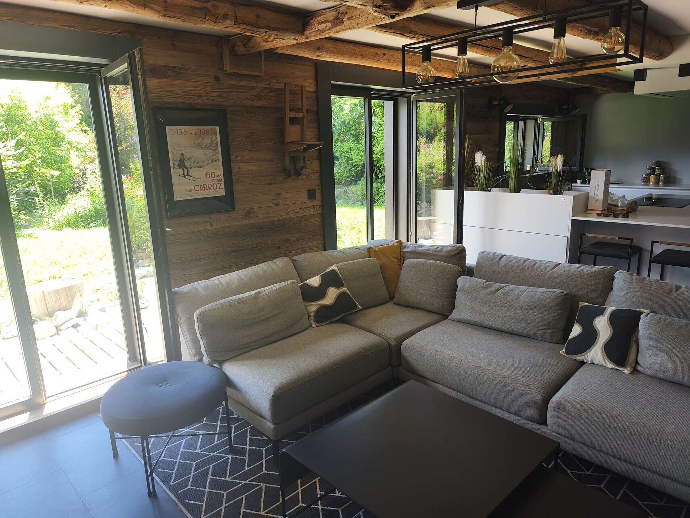 A modern living room with a sectional sofa, a small table, and a large window providing a view of the outdoors.