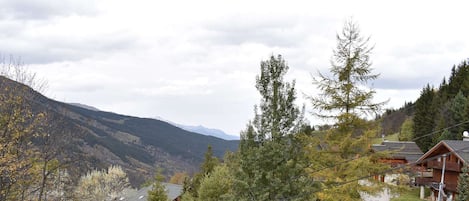 A mountainous landscape with a wooden cabin and a ski lift.