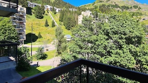 Un quartier résidentiel situé sur une colline, avec une route et des immeubles dotés de balcons.