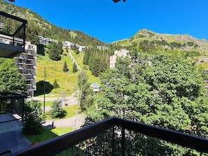 Ein Wohngebiet mit Hanglage, einer Straße und Gebäuden mit Balkonen.