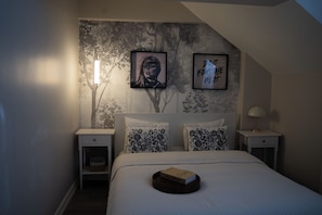 A bedroom with a bed, two nightstands, a wall-mounted lamp, and two framed pictures. - Stylish Duplex with Private Terrace near Taksim Sleeps6 Deniz Apart with cool AC (Istanbul)