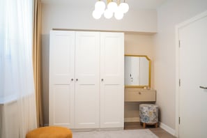 A room with a wardrobe, a mirror, and a small stool. - Stylish Duplex with Private Terrace near Taksim Sleeps6 Deniz Apart with cool AC (Istanbul)
