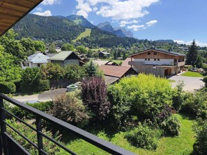 Ein Wohngebiet mit Häusern, einem Holzhaus und einem Berg im Hintergrund.